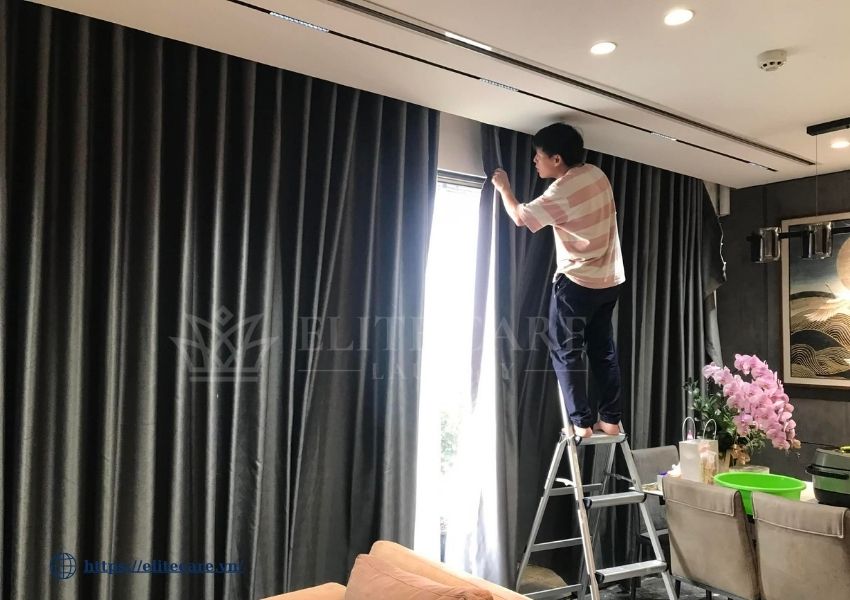 Nhân viên Elite Care Laundry lắp lại rèm sau khi giặt tại nhà khách ở Hà Nội